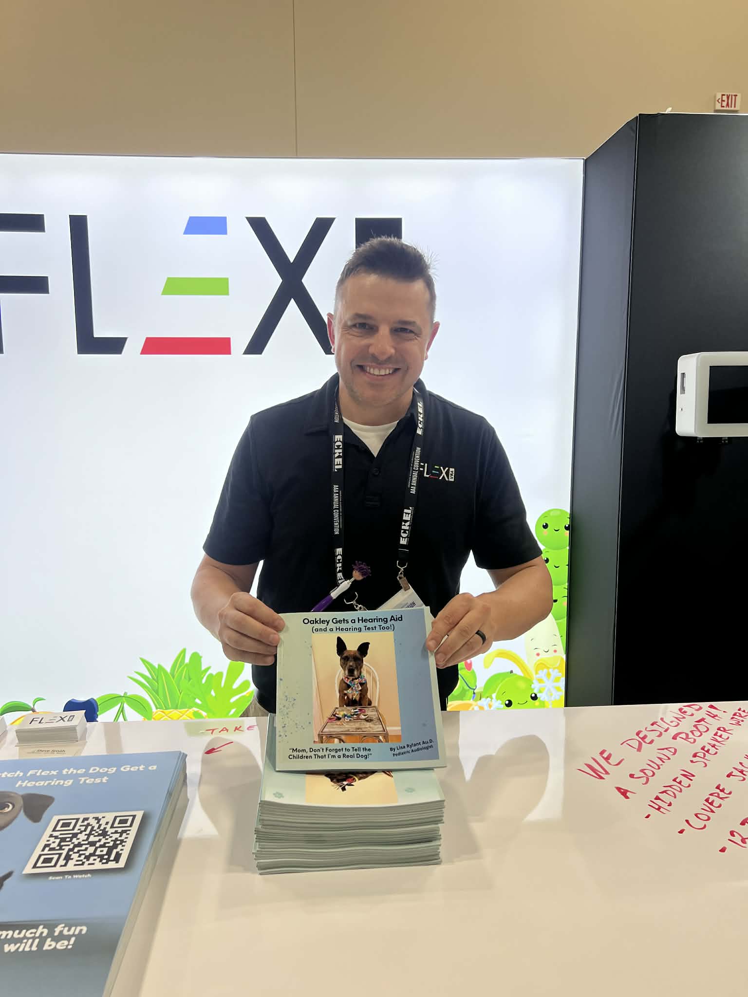 Flex VRA representative holding Oakley's children's book at a professional audiology conference